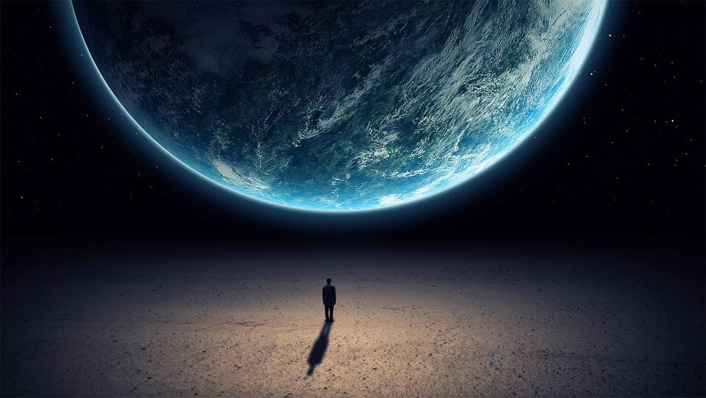 A Man standing in front or Planet Earth